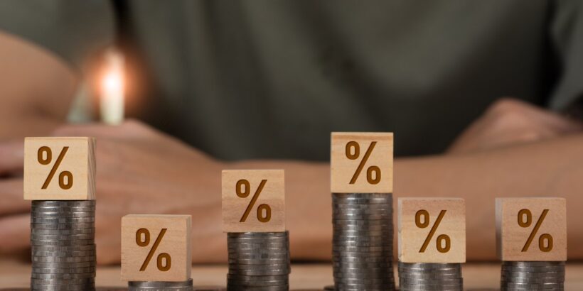 A bunch of coins laid out on a table, with some in tall stacks. The ones in stacks have blocks with percentage signs on them.