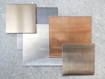 A few squares of aluminum with different colors and finishes stacked together. The stack is offset to show each square off.