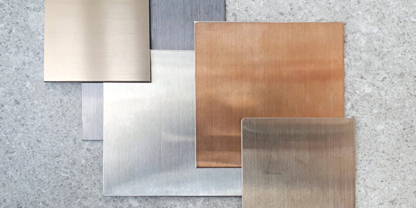 A few squares of aluminum with different colors and finishes stacked together. The stack is offset to show each square off.